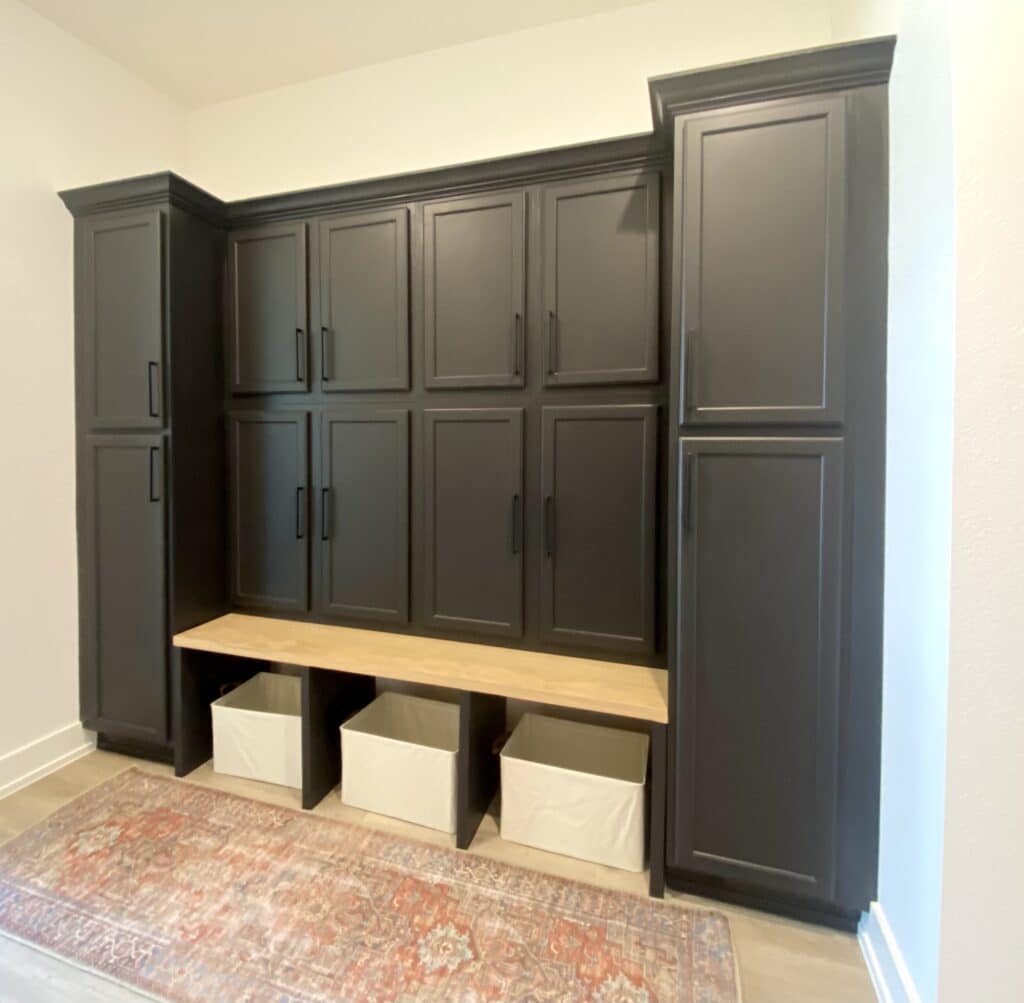 Finished black mudroom lockers with doors and white oak bench