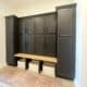 Finished black mudroom lockers with doors and white oak bench