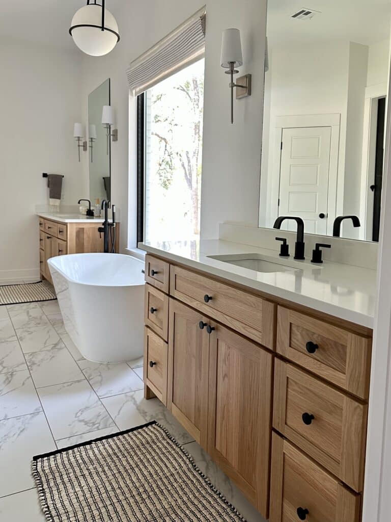 two vanities in bathroom with window and tub