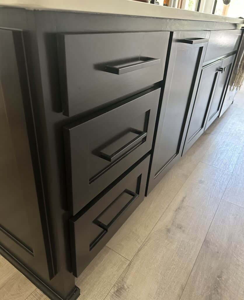 matte black bar pulls on black shaker style kitchen island cabinets