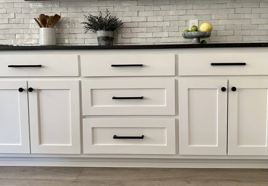 wide matte black bar pulls on white shaker style kitchen cabinets