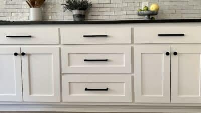 wide matte black bar pulls on white shaker style kitchen cabinets