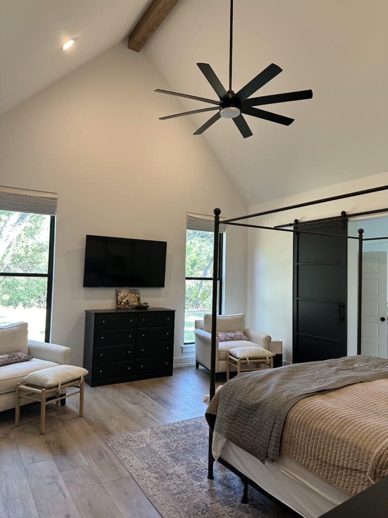 master bedroom with vaulted ceilings and windows